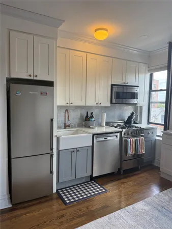 a kitchen with a refrigerator sink and cabinets
