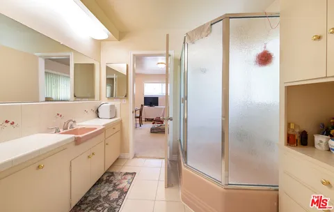 a bathroom with a double vanity sink mirror and shower