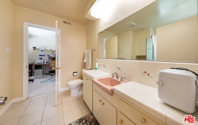a spacious bathroom with a toilet sink and mirror