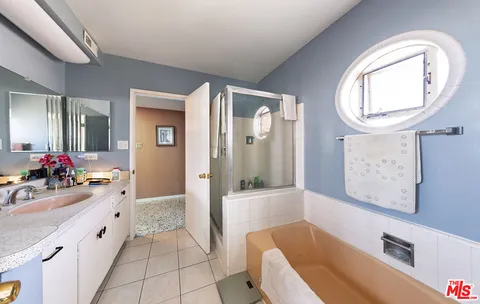 a spacious bathroom with a bathtub sink and mirror