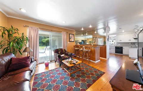 a living room with furniture a wooden floor and a large window