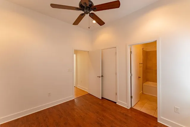 an empty room with a window and a ceiling fan
