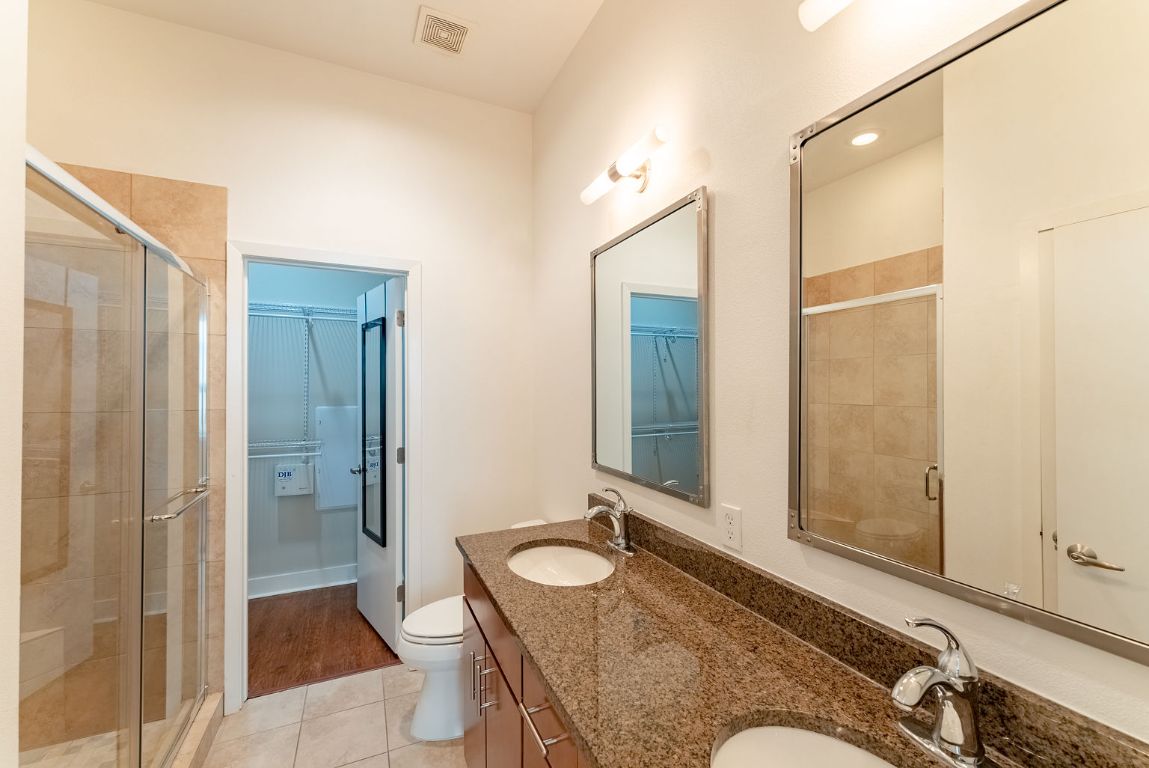 1702 South Lamar Boulevard, Unit 27 Austin, TX 78704 - Photo 17 of 20 Full bath with a walk in closet, double vanity, a shower stall, and light tile patterned flooring