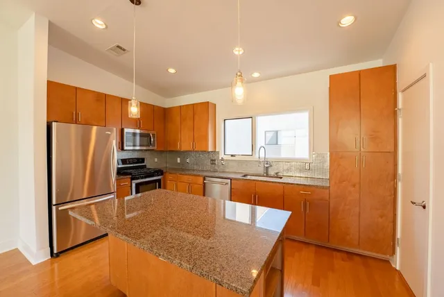 a large kitchen with kitchen island a sink stainless steel appliances and a counter