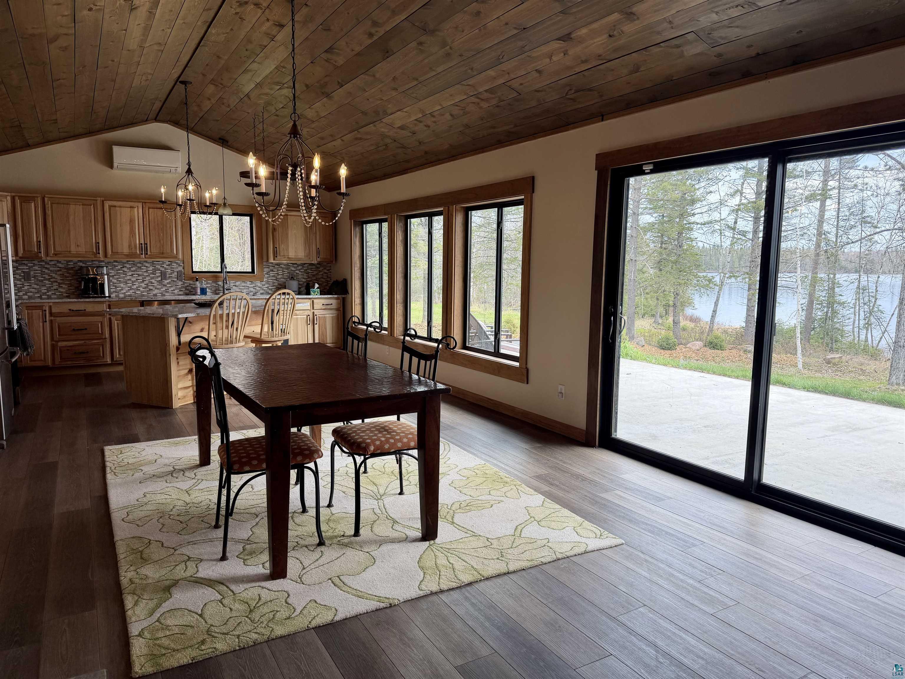 5274 Marble Lake Road Two Harbors, MN 55616 - Photo 12 of 79 Open-concept living space featuring wood-finish flooring, a vaulted wood plank ceiling, and a kitchen with wood cabinetry and a mosaic tile backsplash