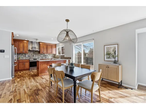 a dining hall with stainless steel appliances kitchen island granite countertop a table and chairs