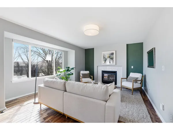 a living room with furniture a fireplace and a large window