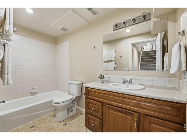 a bathroom with a granite countertop sink toilet a large mirror and shower