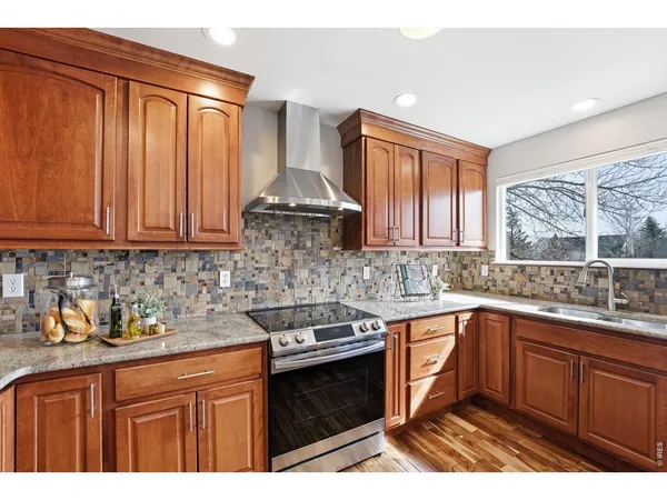 a kitchen with stainless steel appliances granite countertop a sink stove and cabinets
