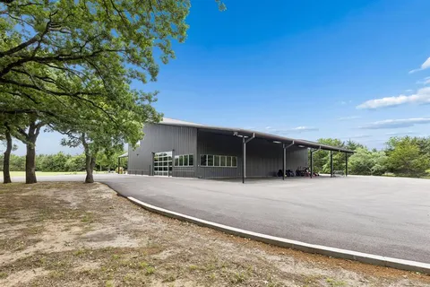 an aerial view of residential houses with outdoor space and trees