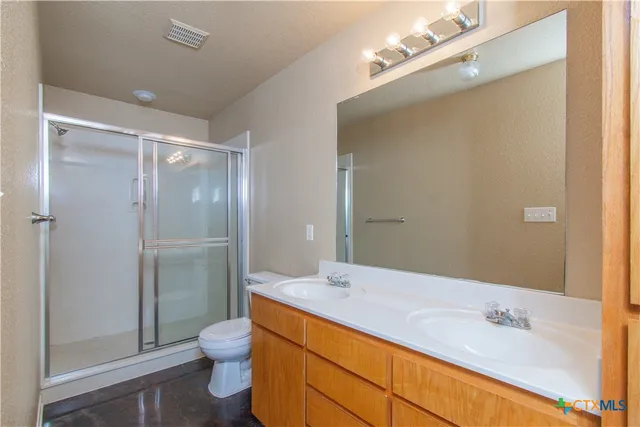 a bathroom with a sink a toilet and shower