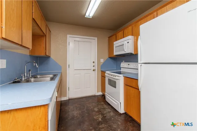 a kitchen with stainless steel appliances a sink a stove and a refrigerator with cabinets