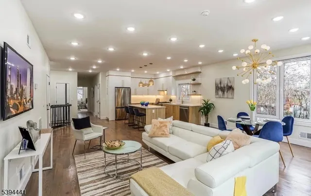 a living room with furniture and a view of kitchen