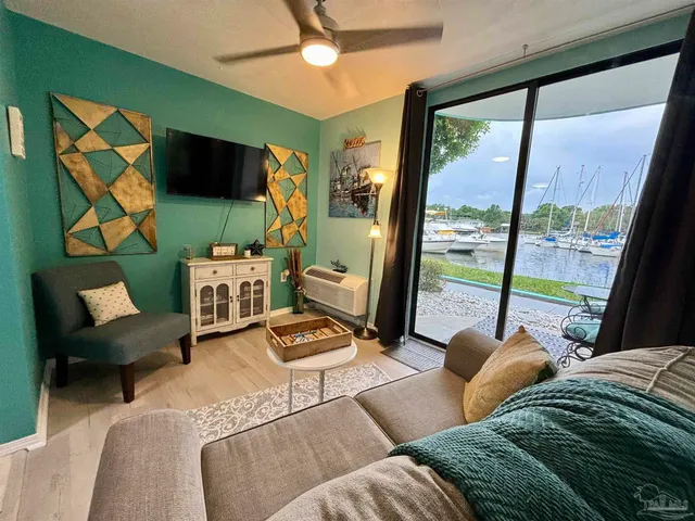 a living room with furniture a flat screen tv and a floor to ceiling window