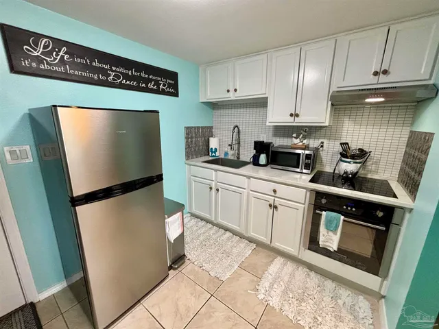 a kitchen with stainless steel appliances a refrigerator sink and cabinets