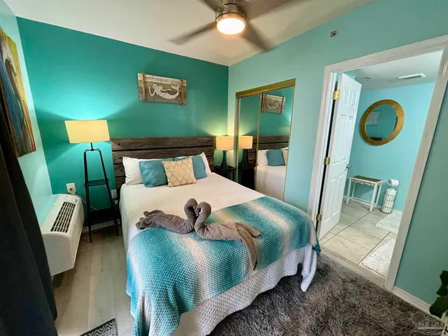 a bedroom with a bed and a mirror on dresser