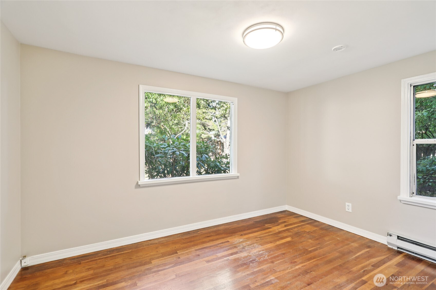 1005 Northeast 170th Street Shoreline, WA 98155 - Photo 19 of 35 an empty room with wooden floor and windows