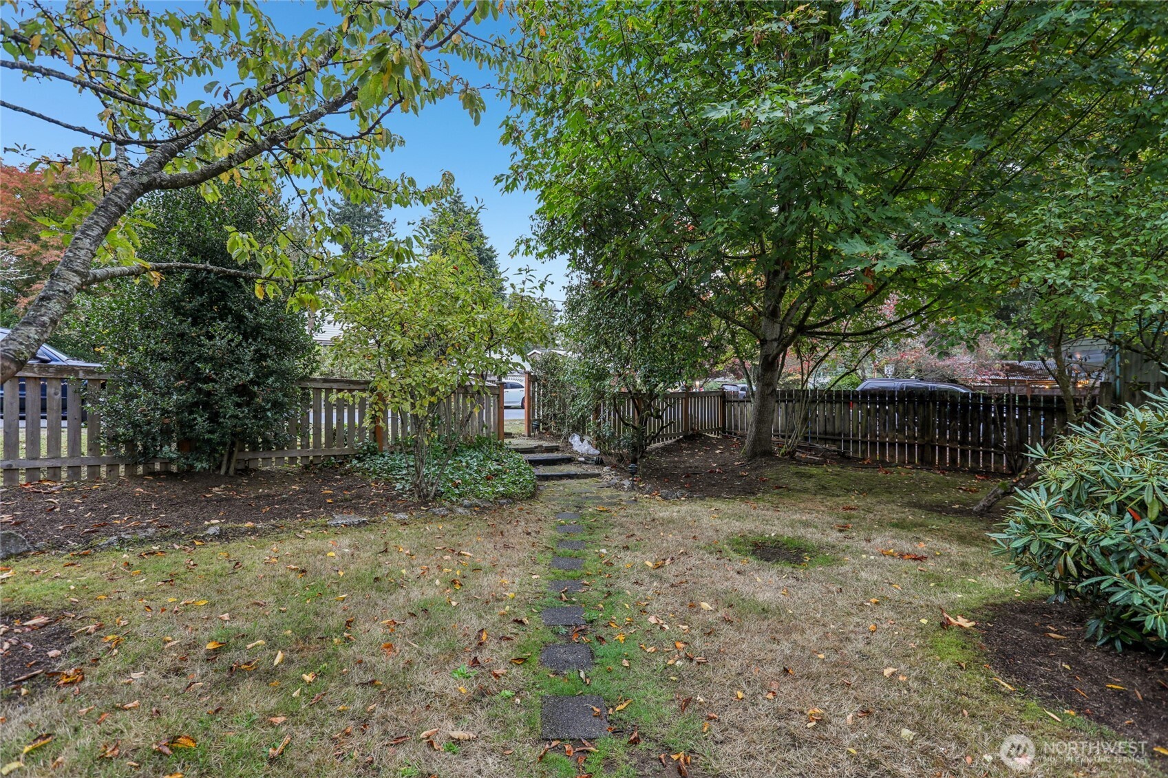 1005 Northeast 170th Street Shoreline, WA 98155 - Photo 26 of 35 a backyard of a house with plants and large trees