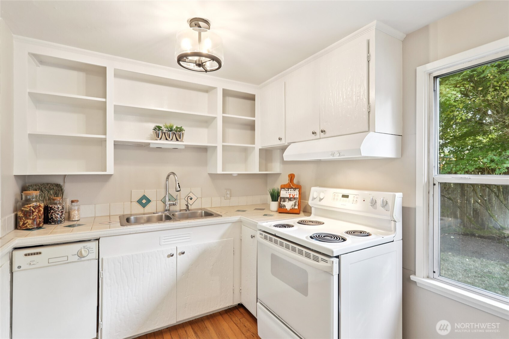 1005 Northeast 170th Street Shoreline, WA 98155 - Photo 6 of 35 a kitchen with kitchen island a sink a stove and wooden floors