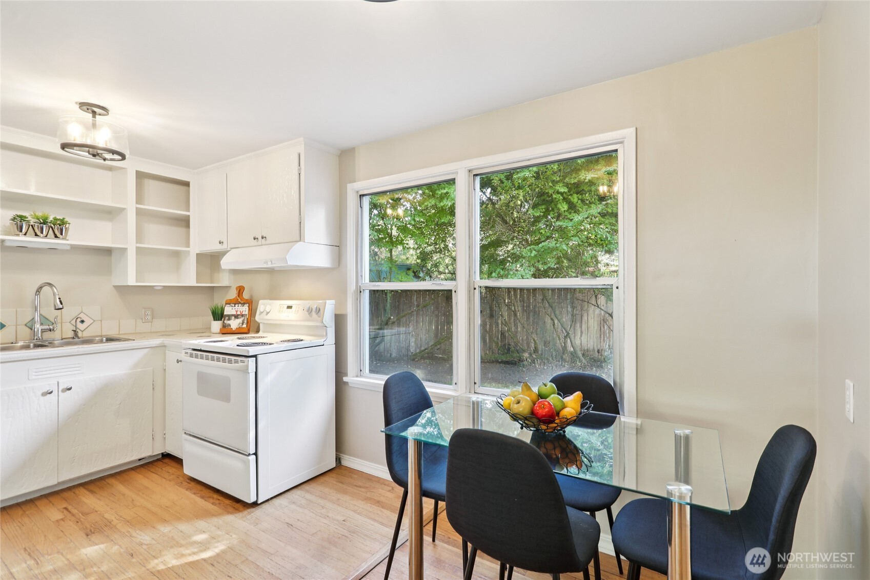 1005 Northeast 170th Street Shoreline, WA 98155 - Photo 10 of 35 a kitchen with stainless steel appliances granite countertop a stove a refrigerator a dining table and chairs next to a window