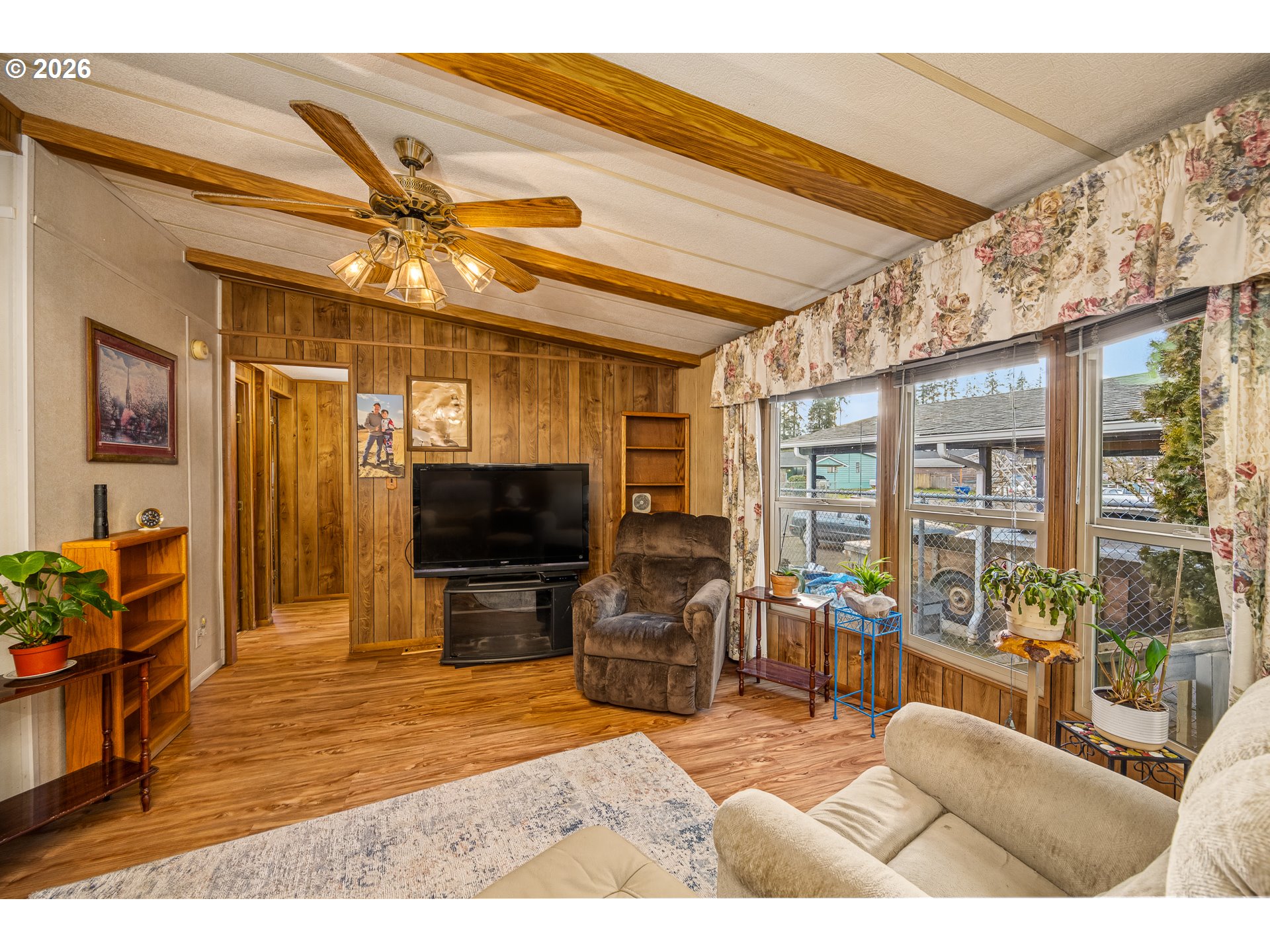 5254 Forsythia Street Springfield, OR 97478 - Photo 5 of 18 a living room with furniture a flat screen tv and a floor to ceiling window