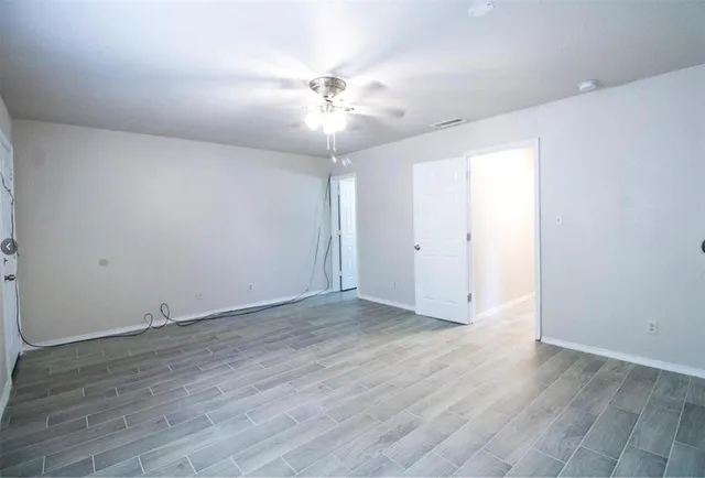 a view of an empty room with wooden floor