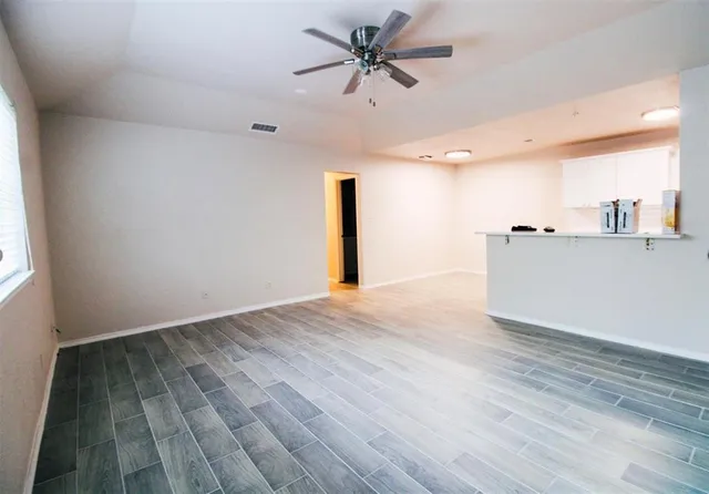 a view of a livingroom with a ceiling fan & wooden floor