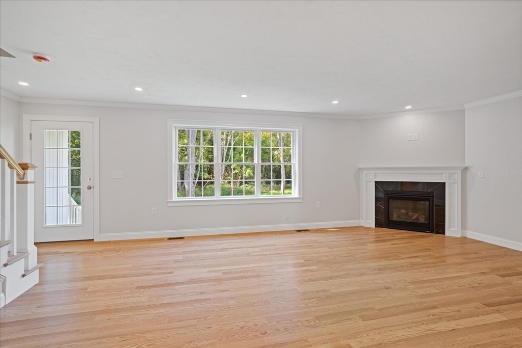 511 Mendon Road, Unit 511 Attleboro, MA 02703 - Photo 14 of 37 an empty room with wooden floor fireplace and windows