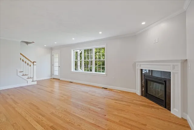 an empty room with windows and fireplace