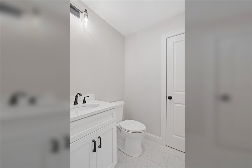 511 Mendon Road, Unit 511 Attleboro, MA 02703 - Photo 17 of 37 a bathroom with a toilet a sink a mirror and vanity