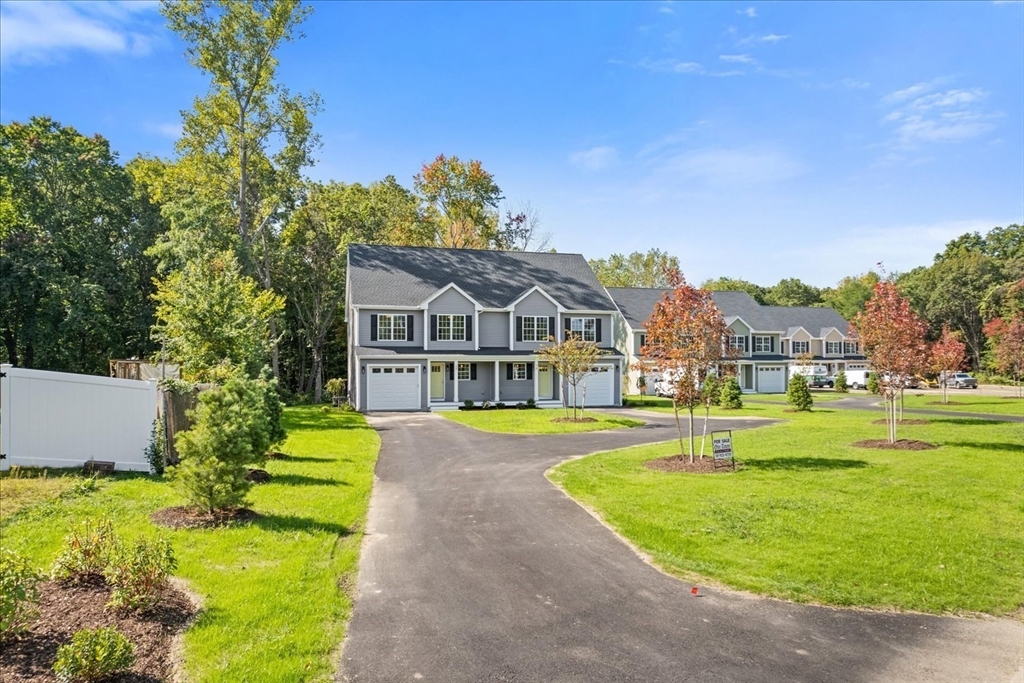 511 Mendon Road, Unit 511 Attleboro, MA 02703 - Photo 4 of 37 a front view of a house with a yard table and chairs