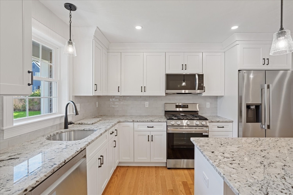 511 Mendon Road, Unit 511 Attleboro, MA 02703 - Photo 7 of 37 a kitchen with granite countertop a sink stove and refrigerator