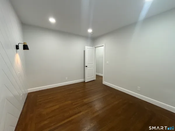 an empty room with wooden floor and closet