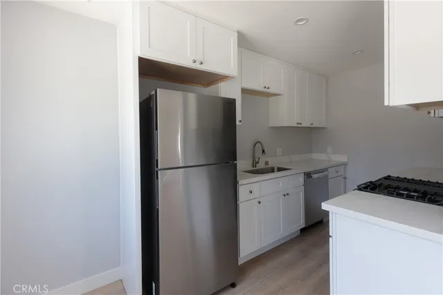 a kitchen with a refrigerator and a stove top oven