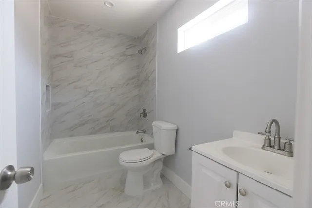 a bathroom with a white toilet sitting next to a sink
