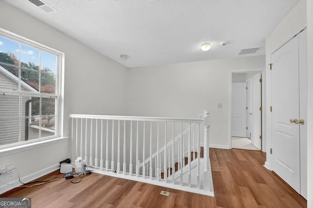 a view of a room with wooden floor and windows