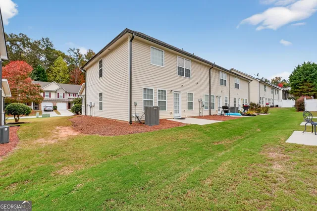 a view of a house with a yard and sitting area