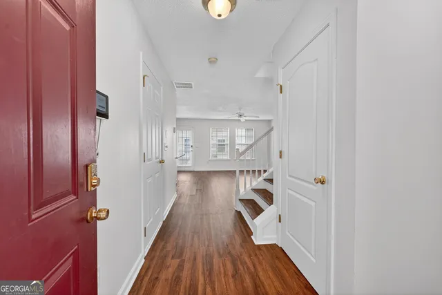 a view of a hallway with wooden floor and staircase