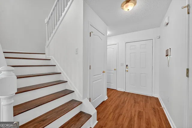 a view of a hallway with wooden floor and entryway
