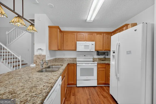 a kitchen with stainless steel appliances granite countertop a refrigerator sink and stove