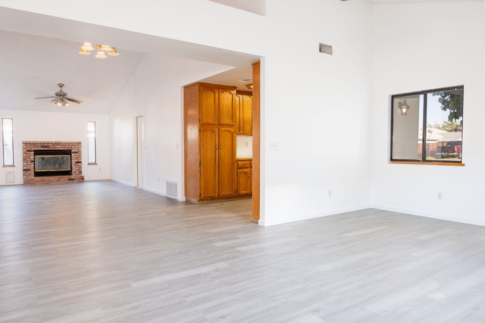 820 Walker Lane Ridgecrest, CA 93555 - Photo 9 of 27 an empty room with wooden floor fire place and windows