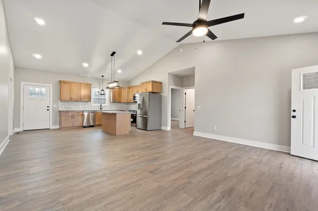 an open kitchen with a refrigerator and a microwave