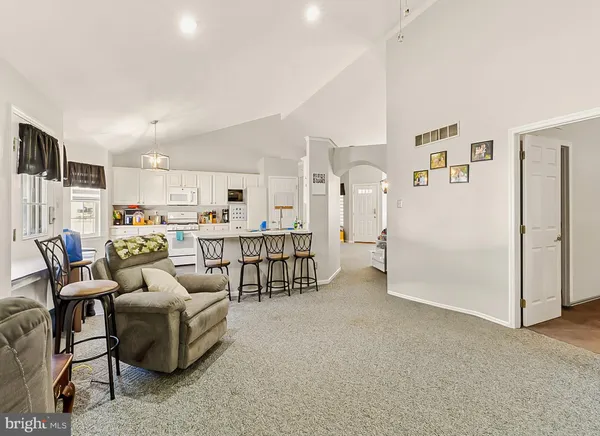 a living room with furniture and a dining table with kitchen view