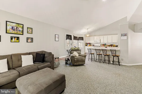 a living room with furniture and kitchen view