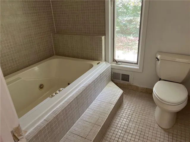 a bathroom with a tub and toilet