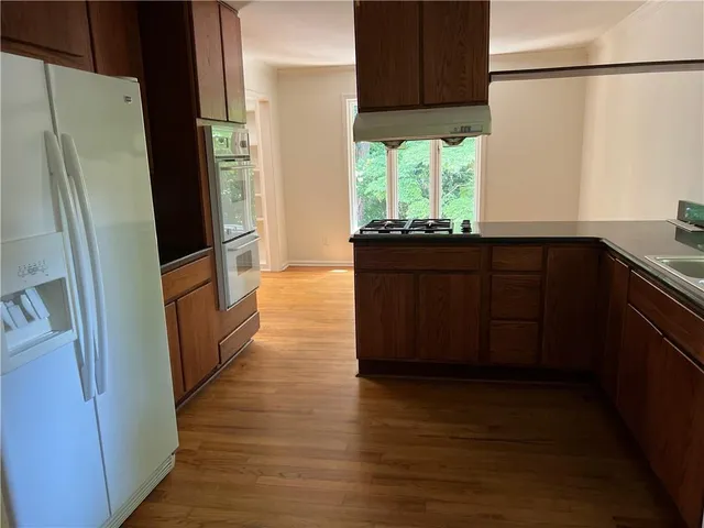 a kitchen with stainless steel appliances granite countertop a refrigerator a sink and a stove