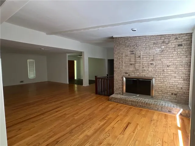 a view of empty room with wooden floor and fireplace