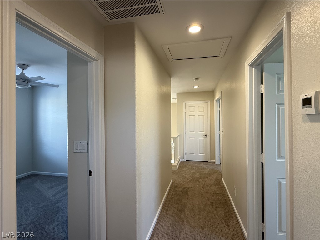 1908 Thunder Ridge Circle Henderson, NV 89012 - Photo 26 of 28 A well-lit hallway with carpeted flooring and multiple doorways leads to various rooms.