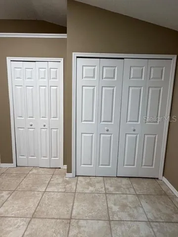 a view of a room with wooden floor and a ceiling fan
