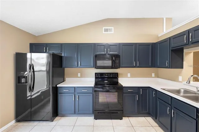 a kitchen with a sink a stove top oven and refrigerator